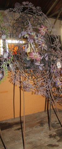 An oval beaded floral display on tripod stand
